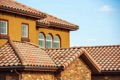 What is the minimum slope for a clay or concrete tile roof?