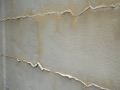 What causes raised white lines of residue on a block wall that are crusty and crumbling?