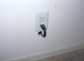 Can I run an electric power cord or extension cord through the wall?