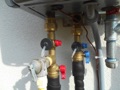 Why should a tankless water heater have an isolator/service valve kit installed?