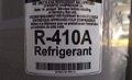 How can I tell if an air conditioner uses R-22 or R-410A refrigerant?