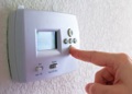 When should I switch the thermostat to EMERGENCY HEAT for my heat pump air conditioner?